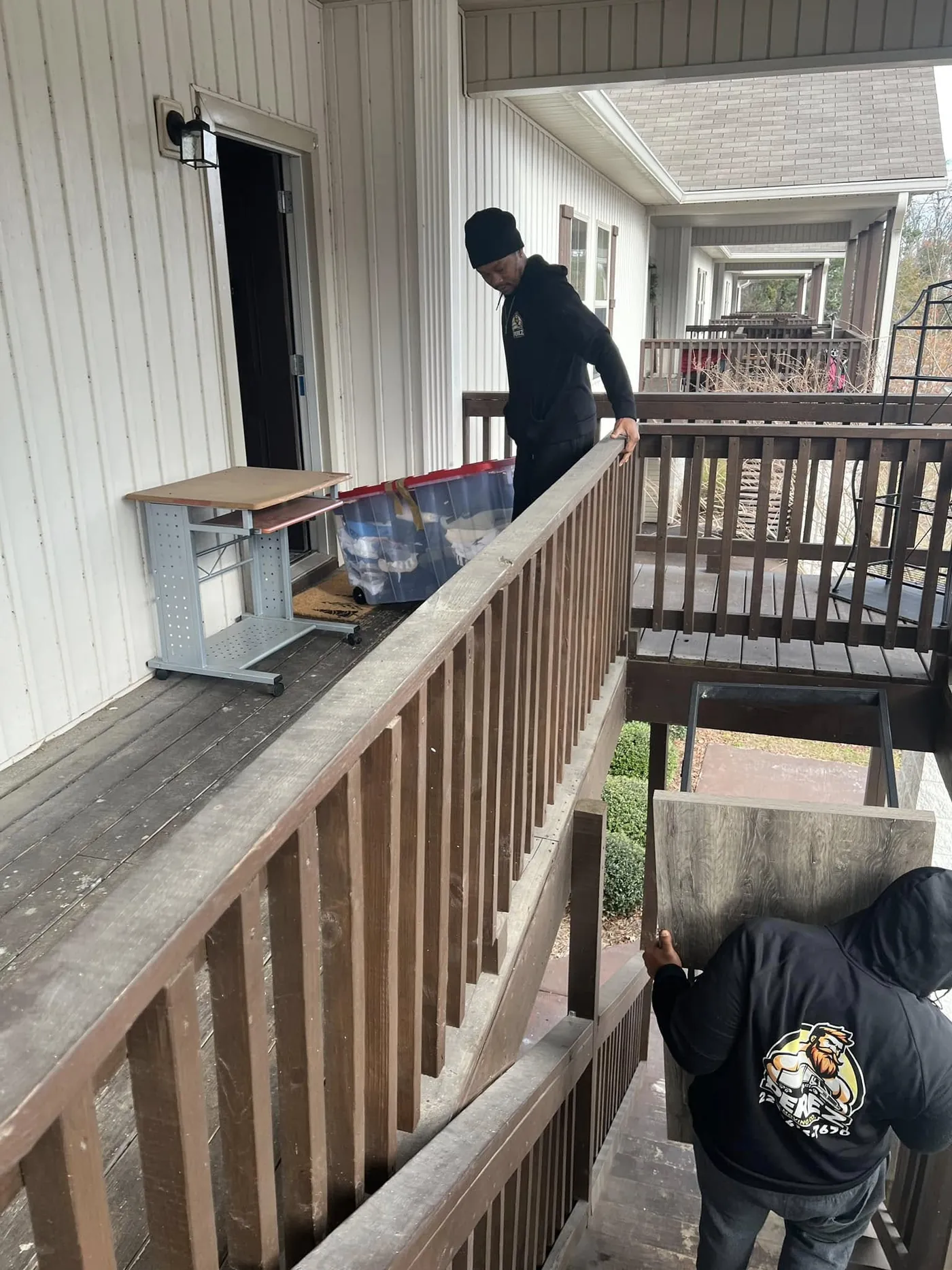 Perez Moving Co mover carefully carrying a wrapped item down a staircase